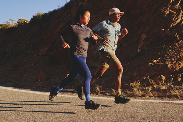 Foto di due persone che corrono con indosso le scarpe da running Hoka Challenger 8