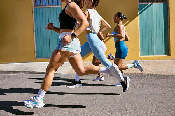 Foto di persone che corrono con indosso le scarpe da running Hoka Clifton 10