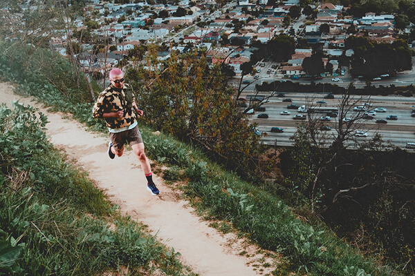 Foto di una persona che corre con indosso le scarpe da gravel running Salomon Aero Blaze 3 Grvl